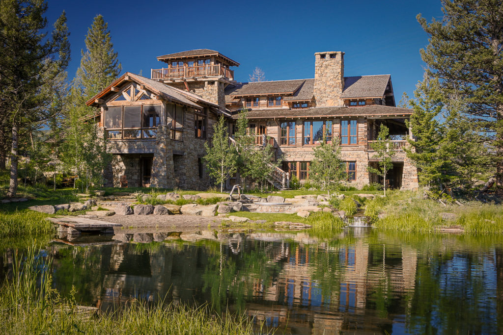 Photo of large stone house with pond